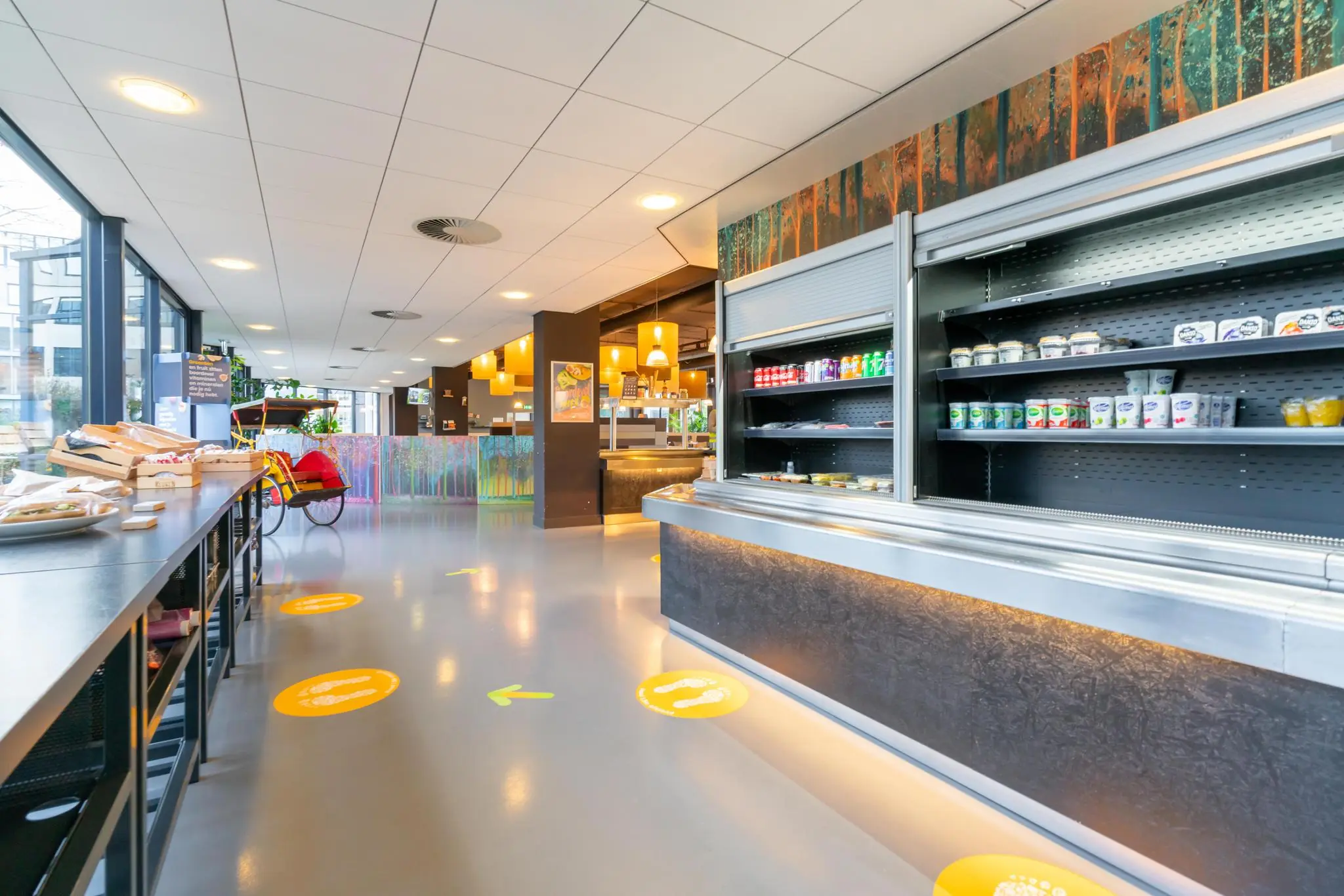 Moderne kantine aan de De Bruyn Kopsstraat met zelfbedieningsvitrine, zitplekken en duidelijke looproutes op de vloer.